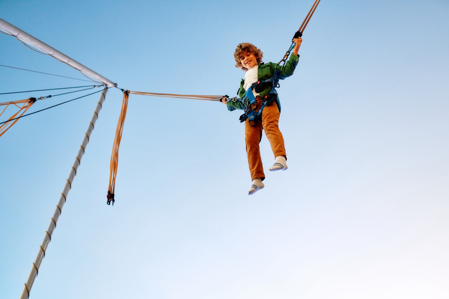 Boy soaring high above a bungee trampoline